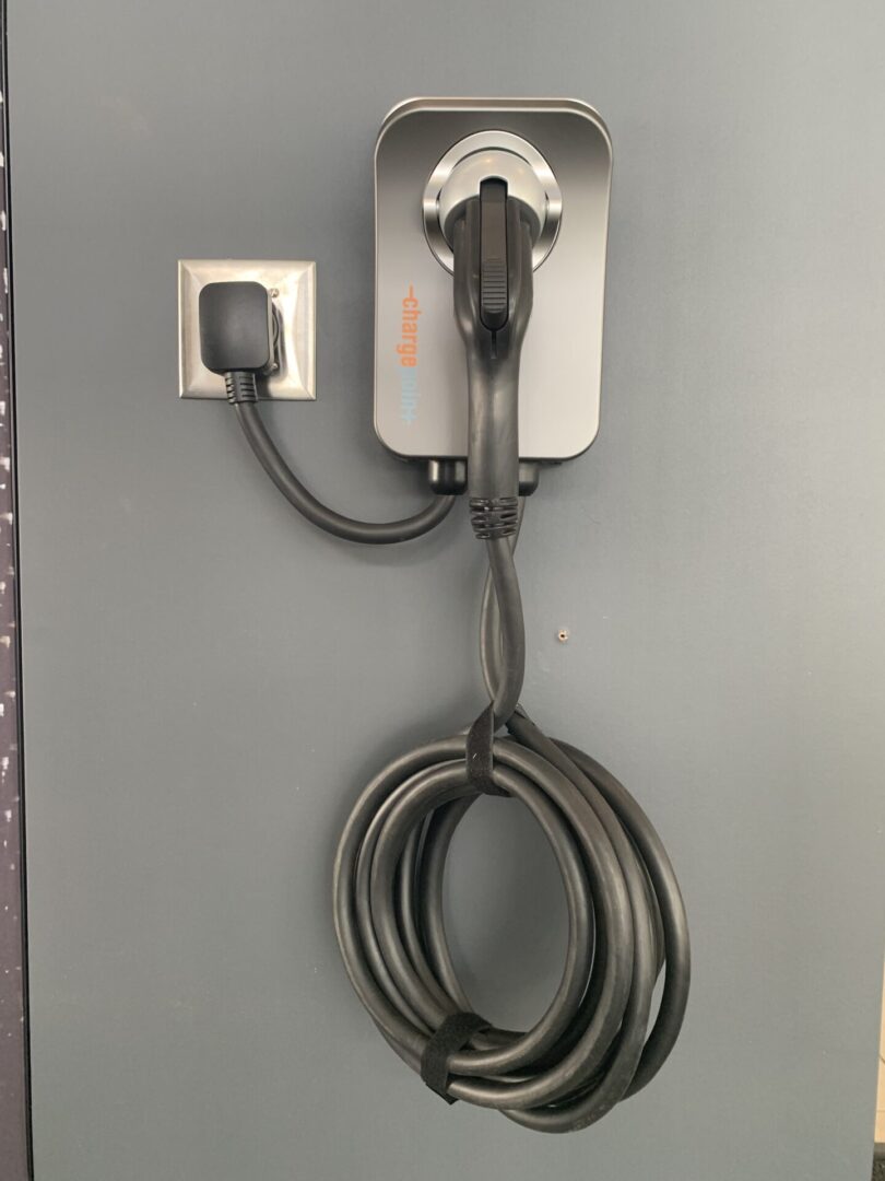 A wall mounted electrical outlet with two wires attached to it.