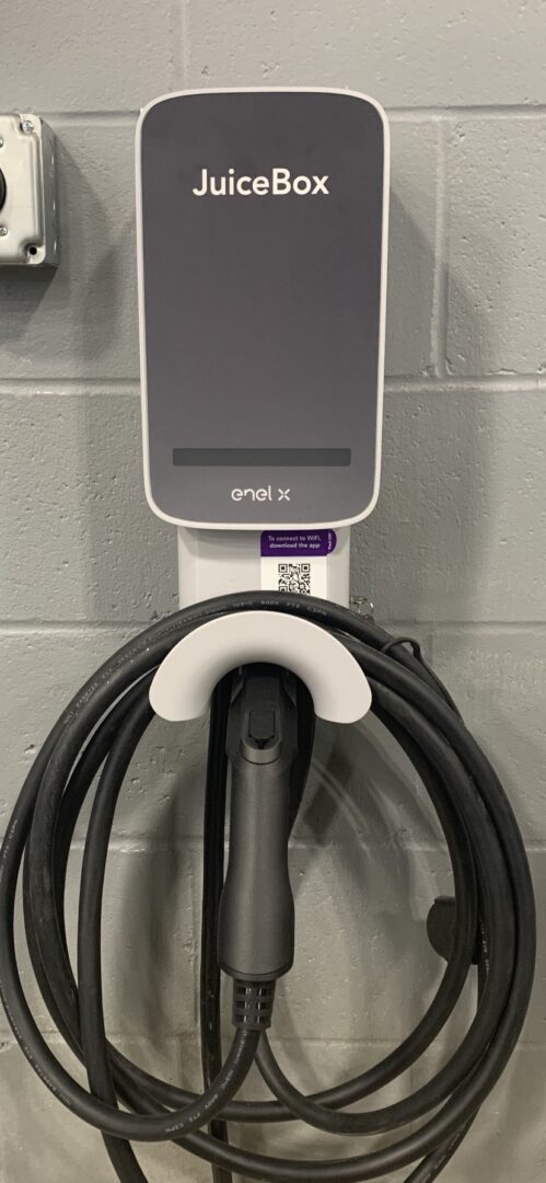 A wall mounted charger with two cords attached to it.