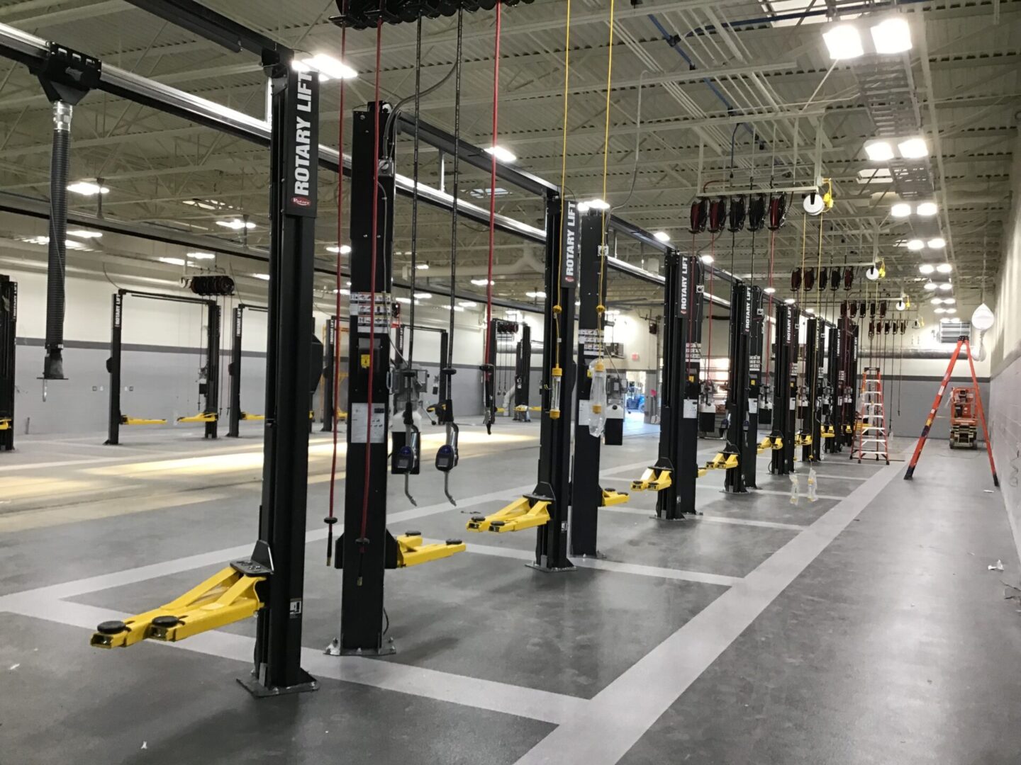 A row of black and yellow car lifts in a garage.