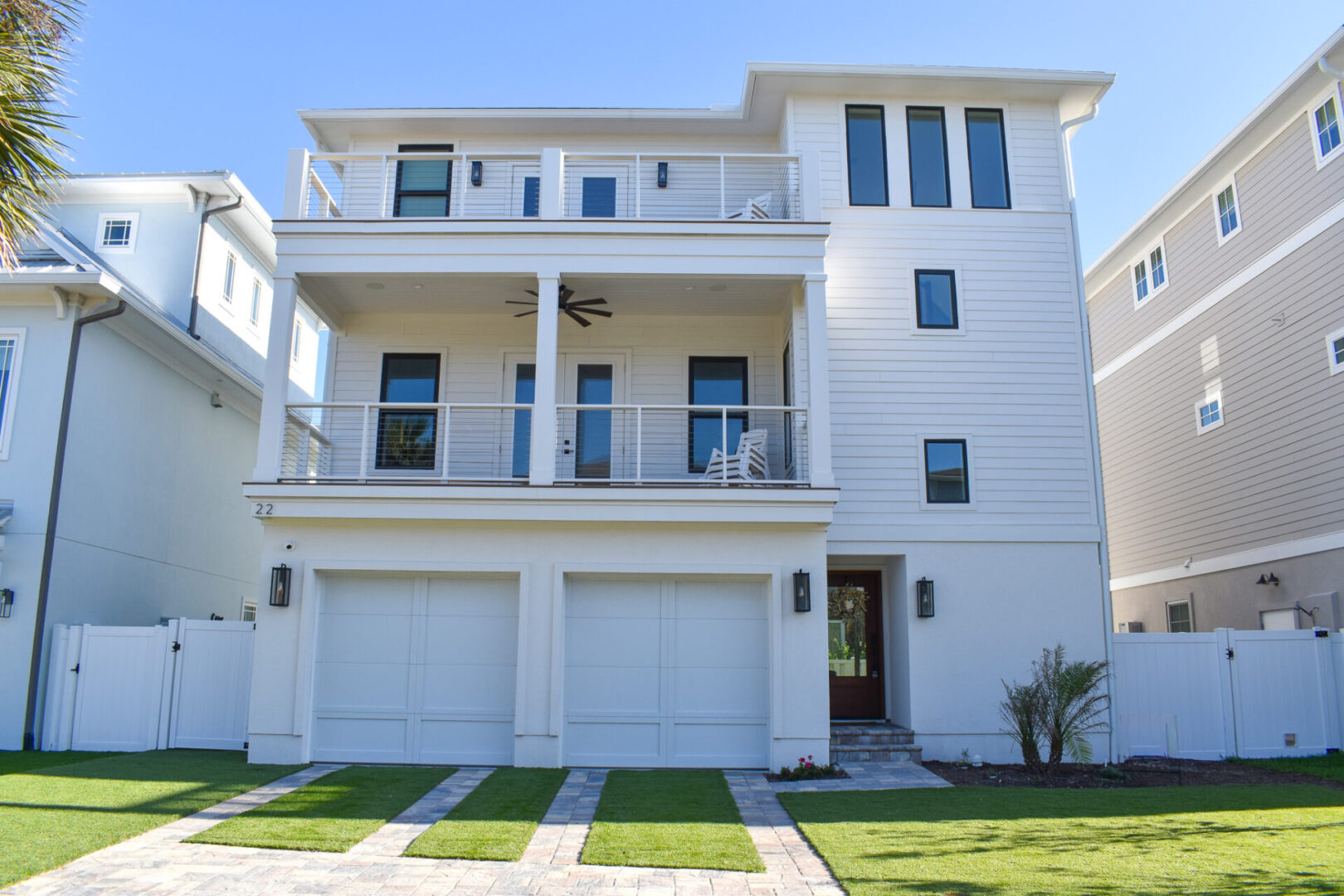 A large white house with two garage doors.