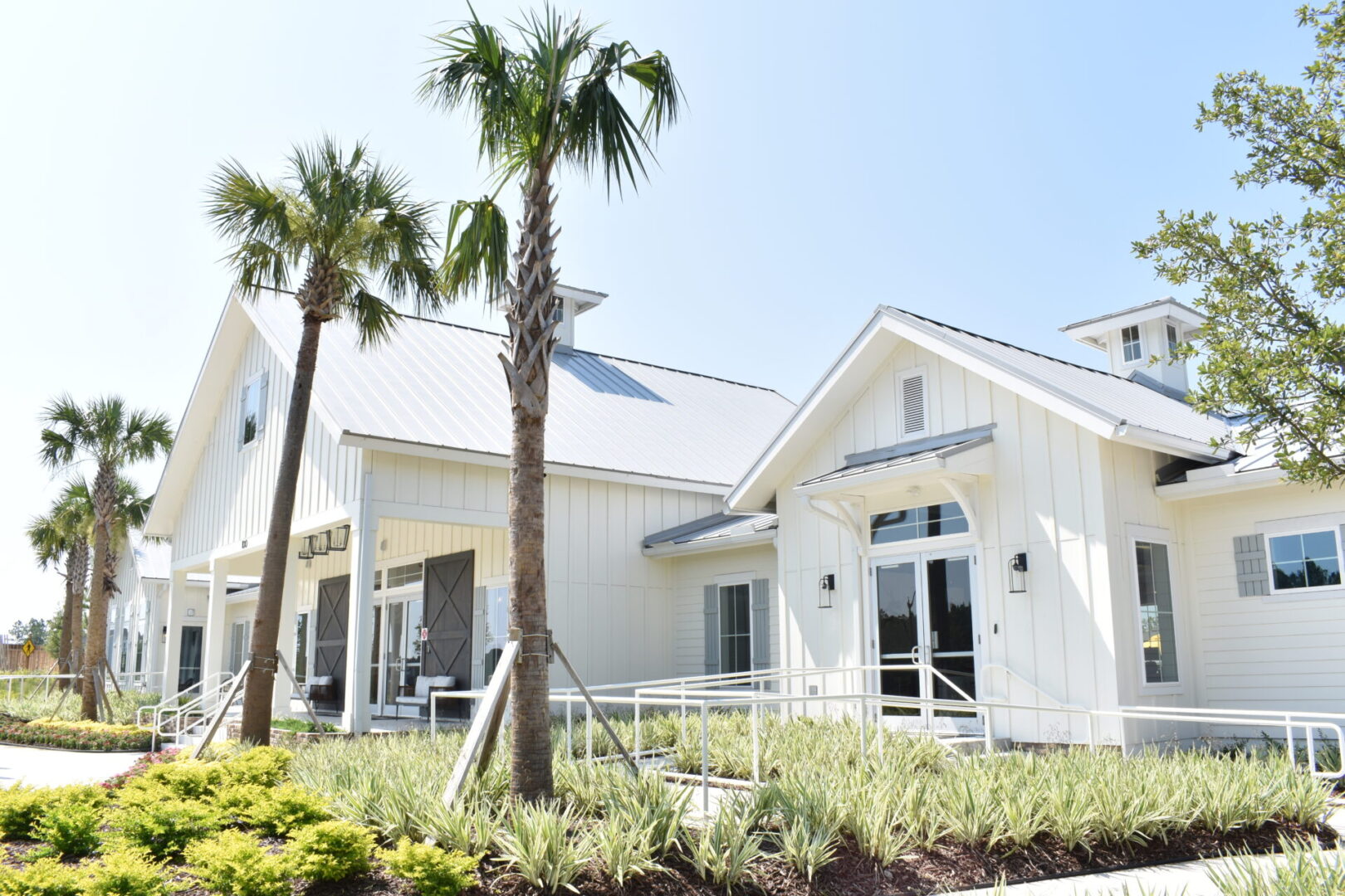 A white house with palm trees and grass